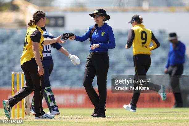 Umpire Ashlee Gibbons hands Chloe Ainsworth of Western Australia her cap during the WNCL match between Western Australia and Victoria at the WACA, on...