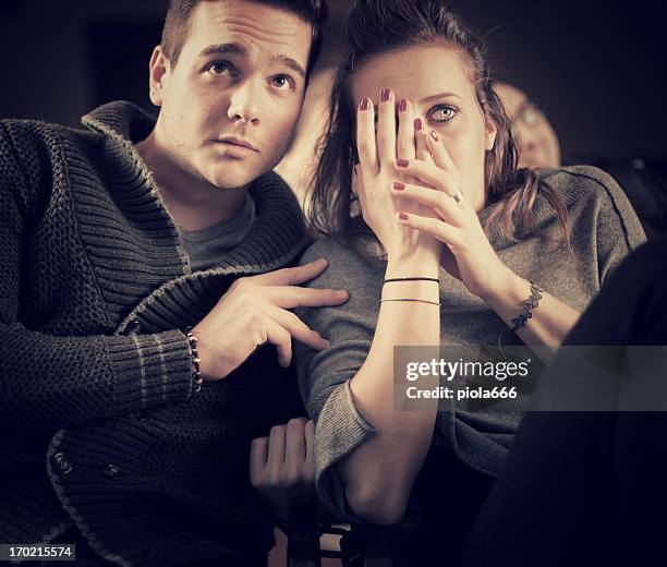 couple scared at the cinema, watching horror movie - amour 2012 film stock pictures, royalty-free photos & images