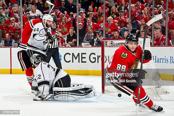 Patrick Kane of the Chicago Blackhawks scores on goalie Jonathan Quick of the Los Angeles Kings, as Robyn Regehr of the Kings watches the puck as it...