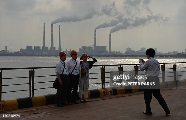 This photo taken on June 6, 2013 shows visitors taking photos at the Baosteel steel mill in Shanghai during a tour of the plant. China's industrial...