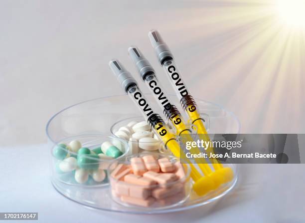 syringes with vaccines for covid and a box with medications for your symptoms. - viral shedding stock-fotos und bilder