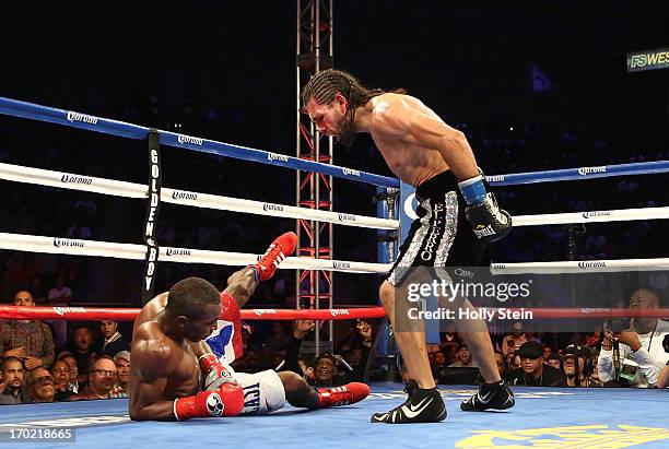 Erislandy Lara stands over Alfredo Angulo after knocking him down during their WBA Interim Super Welterweight title fight at the Home Depot Center on...