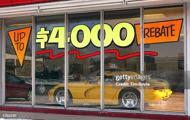 Up To $4,000 Rebate" signage is seen on a window above a $75,750 2002 Dodge Vipor RT/10 in the showroom at the Dodge World automobile dealership...