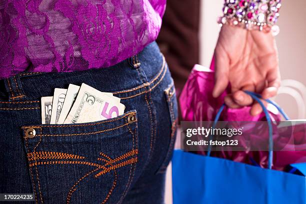 konsum. frau mit geld in der tasche auf der rückseite und einkaufstasche - cash back in your pocket stock-fotos und bilder