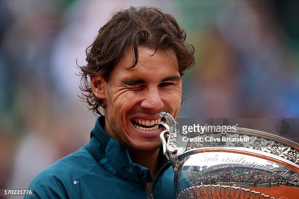 Rafael Nadal of Spain winks as hecelebrates and bites the Coupe des Mousquetaires trophy in the men's singles final against David Ferrer of Spain...