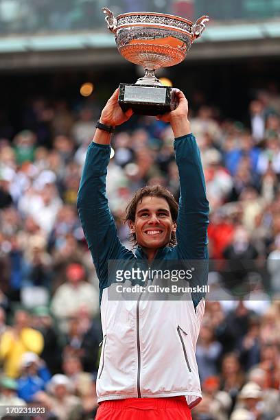 Rafael Nadal of Spain celebrates victory with the Coupe des Mousquetaires trophy in the men's singles final against David Ferrer of Spain during day...