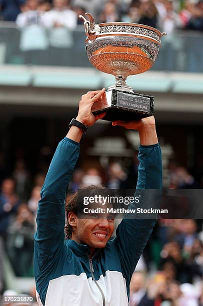 Rafael Nadal of Spain celebrates victory with the Coupe des Mousquetaires trophy in the men's singles final against David Ferrer of Spain during day...