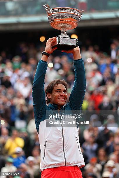 Rafael Nadal of Spain celebrates victory with the Coupe des Mousquetaires trophy in the men's singles final against David Ferrer of Spain during day...