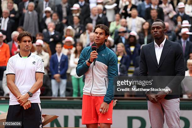 Rafael Nadal of Spain speaks to the crowd next to David Ferrer of Spain and Olympic champion Usain Bolt as he celebrates victory in the men's singles...