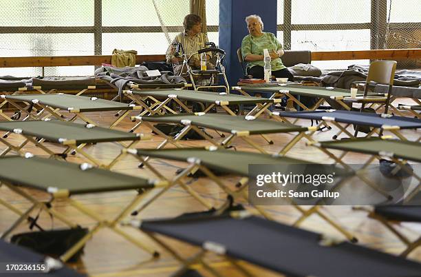 Brigitte Ilsmann who was evacuated from her apartment two days ago, and another eledrly evacuee chat in an evacuation center administered by the...