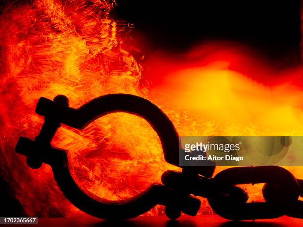 iron shackles. in the background a fire. - concentration camp stock pictures, royalty-free photos & images