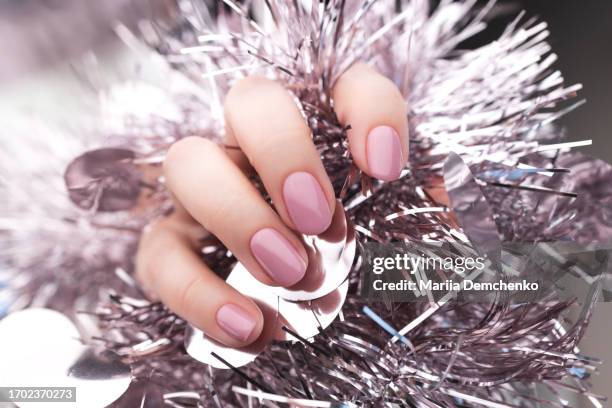 hand with beautiful manicure - pink gel nails with christmas tinsel - beauty salon ukraine - fotografias e filmes do acervo