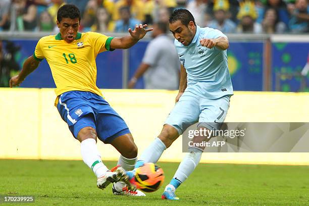 Dimitri Payet of France is challenged by Paulinho of Brazil during the Brazil vs France friendly match at Arena of Gremio stadium on June 9, 2013 in...