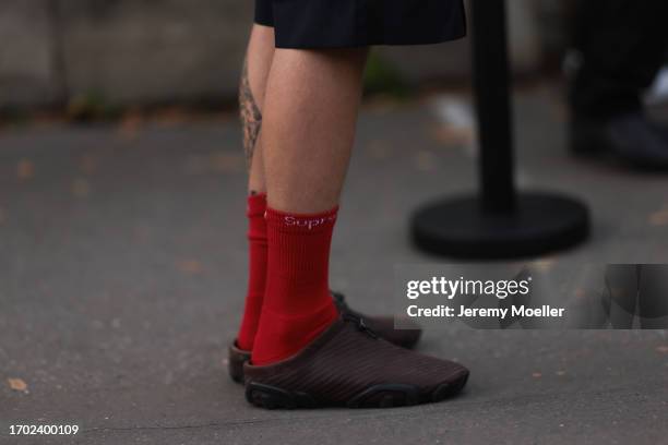 Guest is seen Outside Peter Do show wearing red Supreme socks and brown slip ons during the Womenswear Spring/Summer 2024 as part of Paris Fashion...