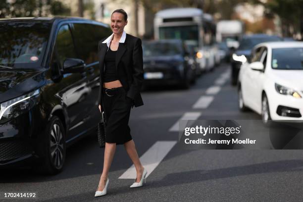 Guest is seen Outside Peter Do show wearing black tank top, black blazer with white colar, black midi pencil skirt with big black belt, black Bottega...