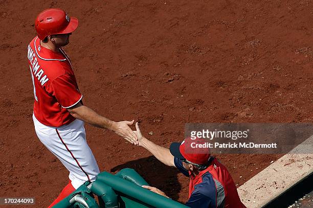 Ryan Zimmerman of the Washington Nationals celebrates with manager Davey Johnson after scoring a run in the fifth inning during a game against the...