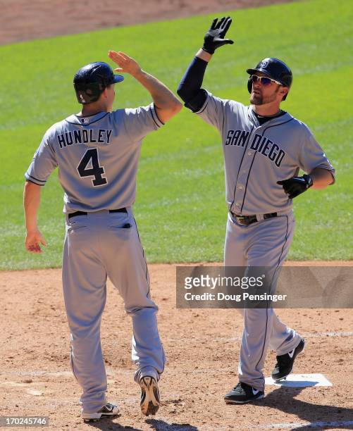 Mark Kotsay of the San Diego Padres celebrates his pinch hit two run home run off of Edgmer Escalona of the Colorado Rockies with Nick Hundley of the...