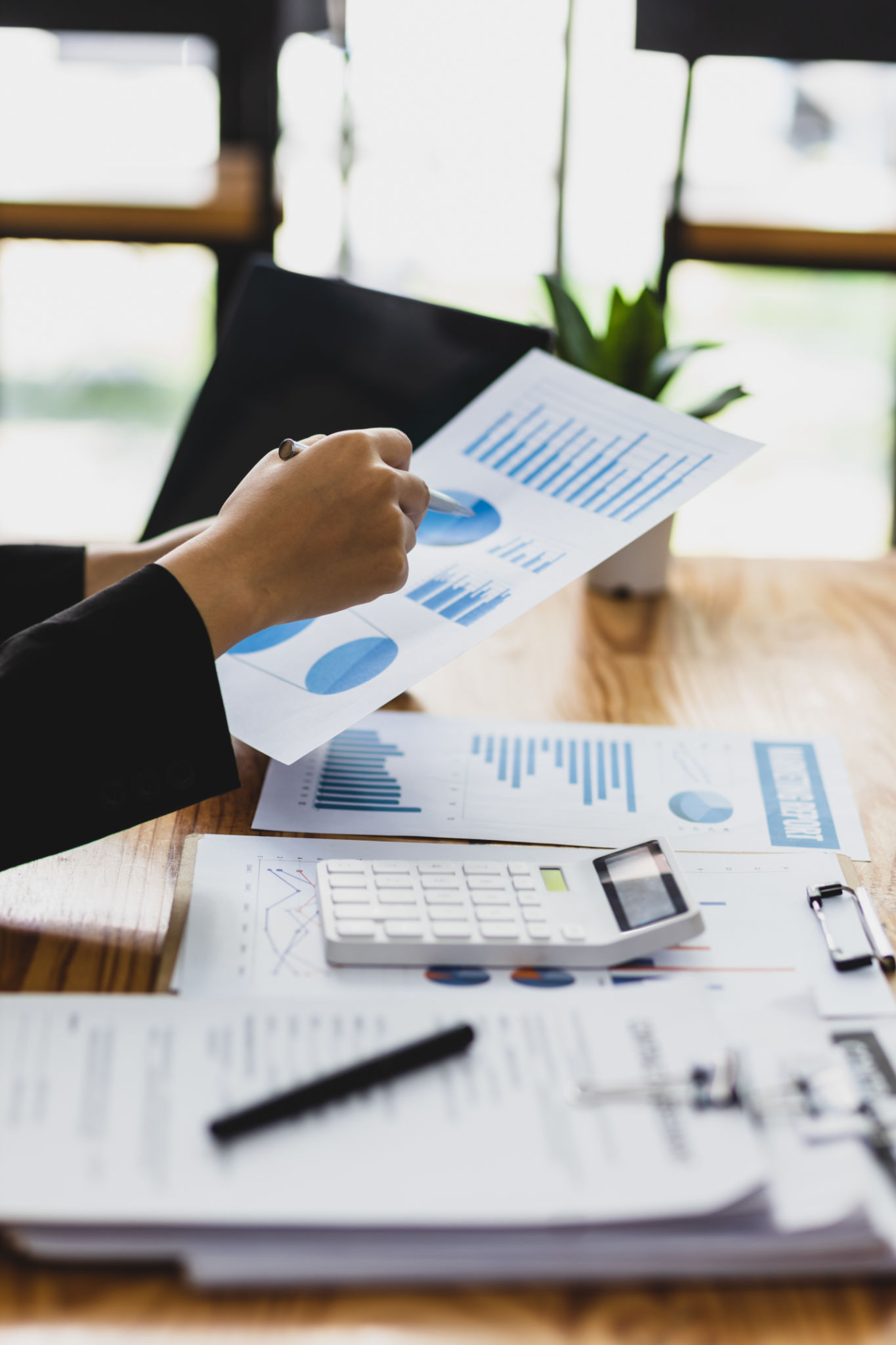 Businesswoman working on paperwork, Analysis of financial report documents and investment charts on laptop. Businesswoman working on paperwork, Analysis of financial report documents and investment charts on laptop.