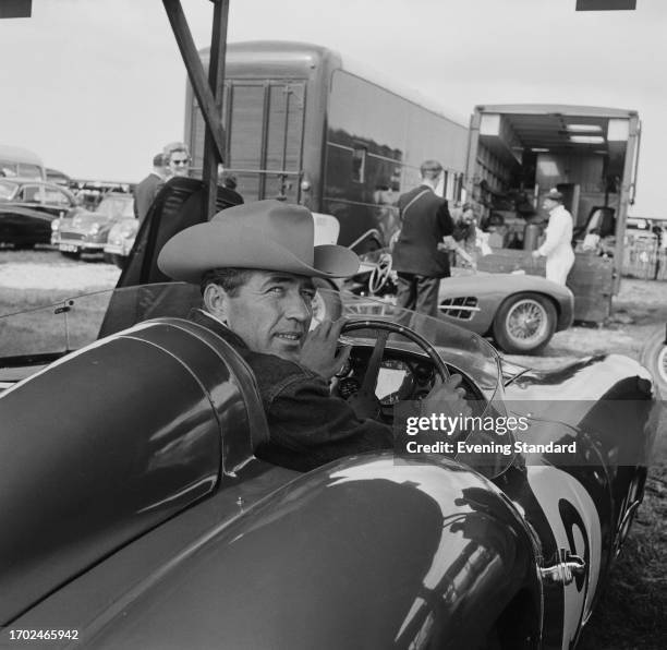 American racing driver Carroll Shelby sits in an Aston Martin DBR 1/300 race car in the paddock ahead of the RAC Tourist Trophy race, Goodwood,...