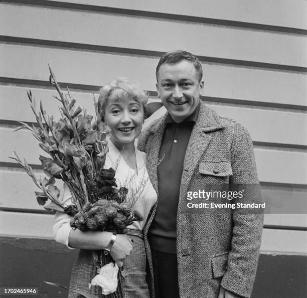 French actress Colette Brosset holds a bouquet while standing beside her husband, actor Robert Dhéry , September 19th 1958.