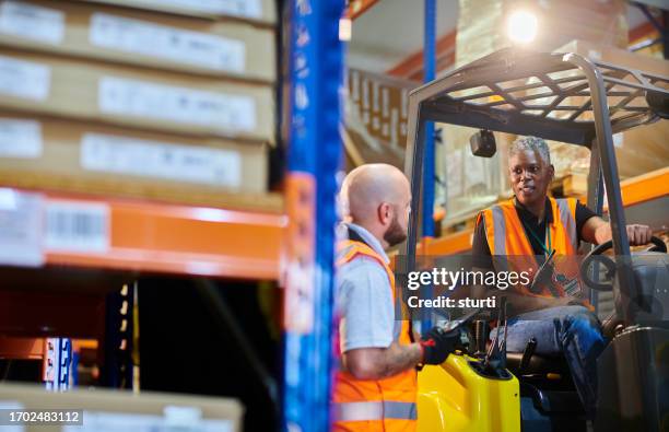 female fork lift driver with colleague - ware house worker forklift stock pictures, royalty-free photos & images