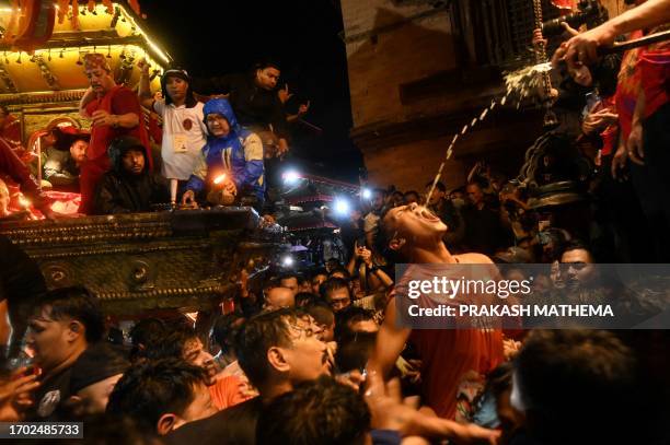 Devotee drinks wine as an offering for Sweta Bhairav, the god of protection, on the last day of the 'Indra Jatra' festival at Durbar Square in...