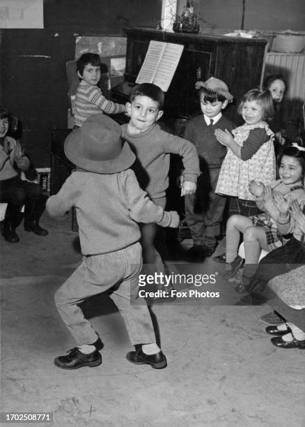 Jamaican schoolboy Danez Rowe, with his back to the camera, dancing the twist with his Cypriot classmate Paul Paulakis, as British schoolgirl Karen...