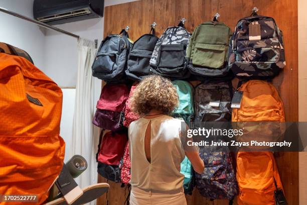 female clothing store owner arranging items of stock along clothing racks and keeping the shop tidy - pre labeled 個照片及圖片檔