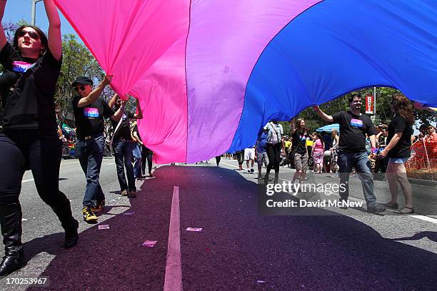 People marching with anBi, a bisexual organization, carry a bisexual flag in the 43rd L.A. Pride Parade on June 9, 2013 in West Hollywood,...