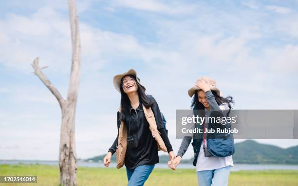 two teenage girls running on meadow at field - cam girl stock pictures, royalty-free photos & images
