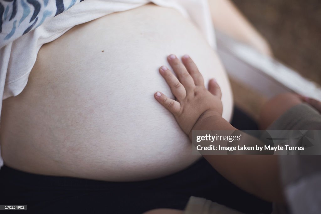 Baby hand in pregnant belly