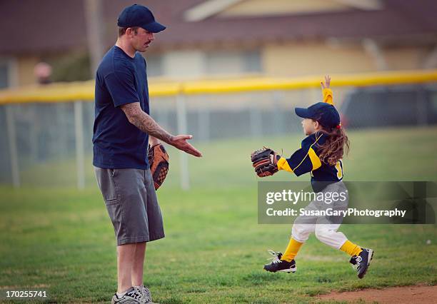 happy girl and father at t-ball game - baseball kid stock-fotos und bilder