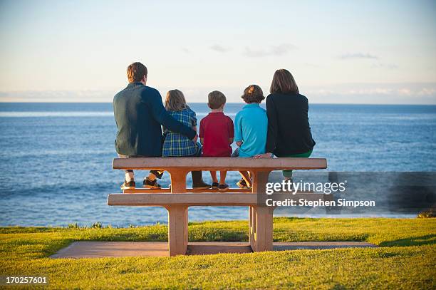 family on picnic bench by the ocean - family with three children fotografías e imágenes de stock