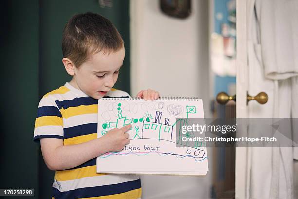 young boy with his drawing - kid presenting stockfoto's en -beelden