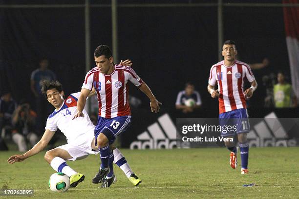 Matias Fernandez of Chile and Miguel Samudio of Paraguay fights for the ball during the match between Paraguay and Chile as part of the South...