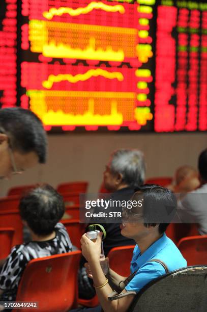 Chinese investors check their stock prices at a securities firm in Hefei, east China's Anhui province on July 7, 2011. Asian stocks were mixed in...
