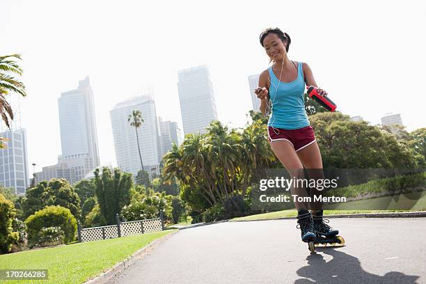 woman on inline skates looking at mp3 player - inline skate bildbanksfoton och bilder