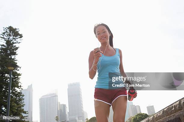 woman on inline skates looking at mp3 player - skaten stockfoto's en -beelden