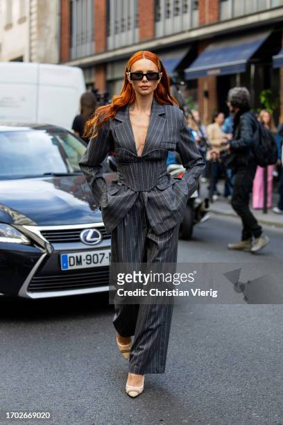 Evelyn Kazantzoglou wears grey striped oversized suit, corset, sunglasses outside Victoria/Tomas during the Womenswear Spring/Summer 2024 as part of...