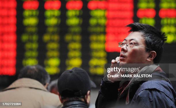 Chinese investor looks at a stock price board showing falling prices at a private securities firm in Shanghai, 17 January 2008. Chinese share prices...