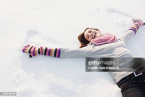 woman making snow angel - snow angel 個照片及圖片檔