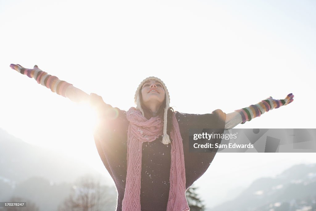 Mulher com os braços abertos na Neve