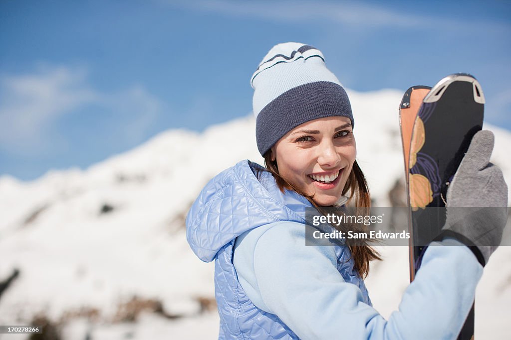 Frau holding skier