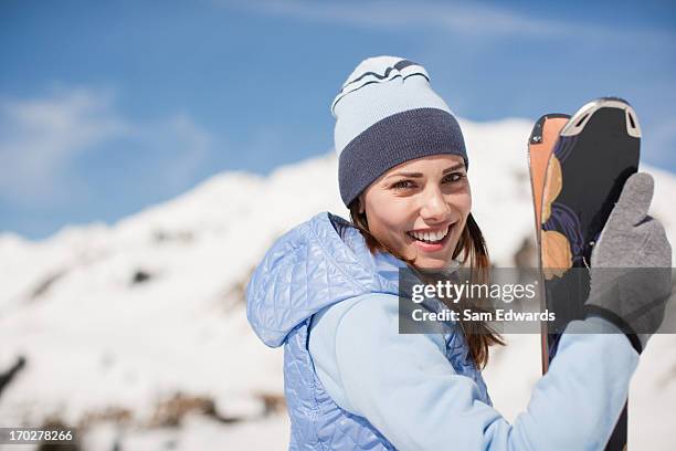 femme tenant des skis - sport hiver photos et images de collection