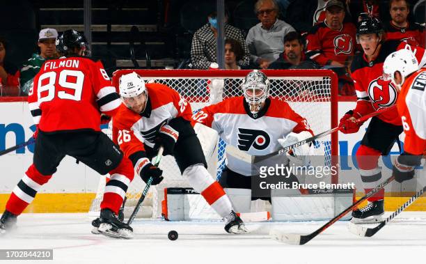 Sean Walker and Felix Sandstrom of Philadelphia Flyers skate against the New Jersey Devils at a preseason game at the Prudential Center on September...
