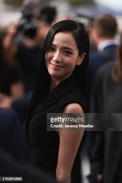 Jisoo of Blackpink is seen wearing a complete outfit from Christian Dior, consisting of a sleeveless, black wool, mini dress with lapel collar and...