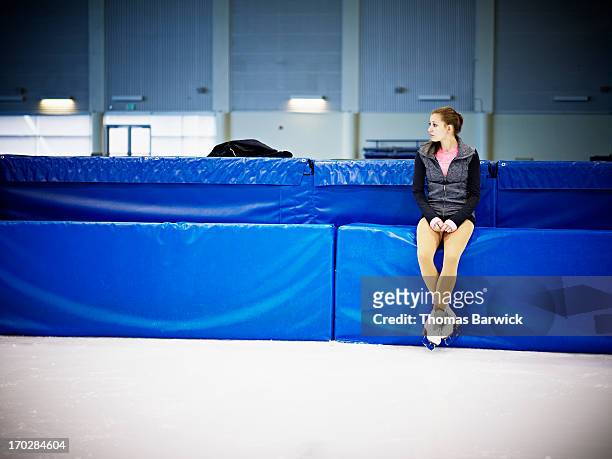 female figure skater sitting on pad on ice rink - figure skating rink stock pictures, royalty-free photos & images