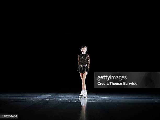 smiling young female figure skater standing on ice - フィギュアスケート　1人　競争　全身 ストックフォトと画像