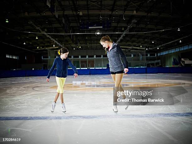 figure skater teaching young student on ice - figure skating girl stock pictures, royalty-free photos & images