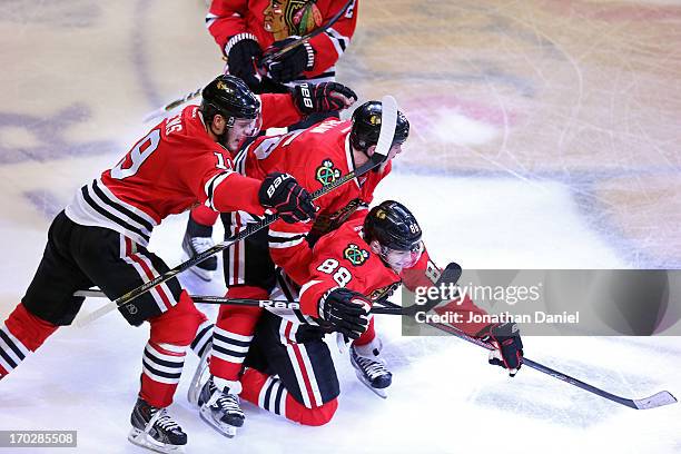 Jonathan Toews, Andrew Shaw and Patrick Kane of the Chicago Blackhawks celebrate after Kane scored the game-winning goal in the second overtime...